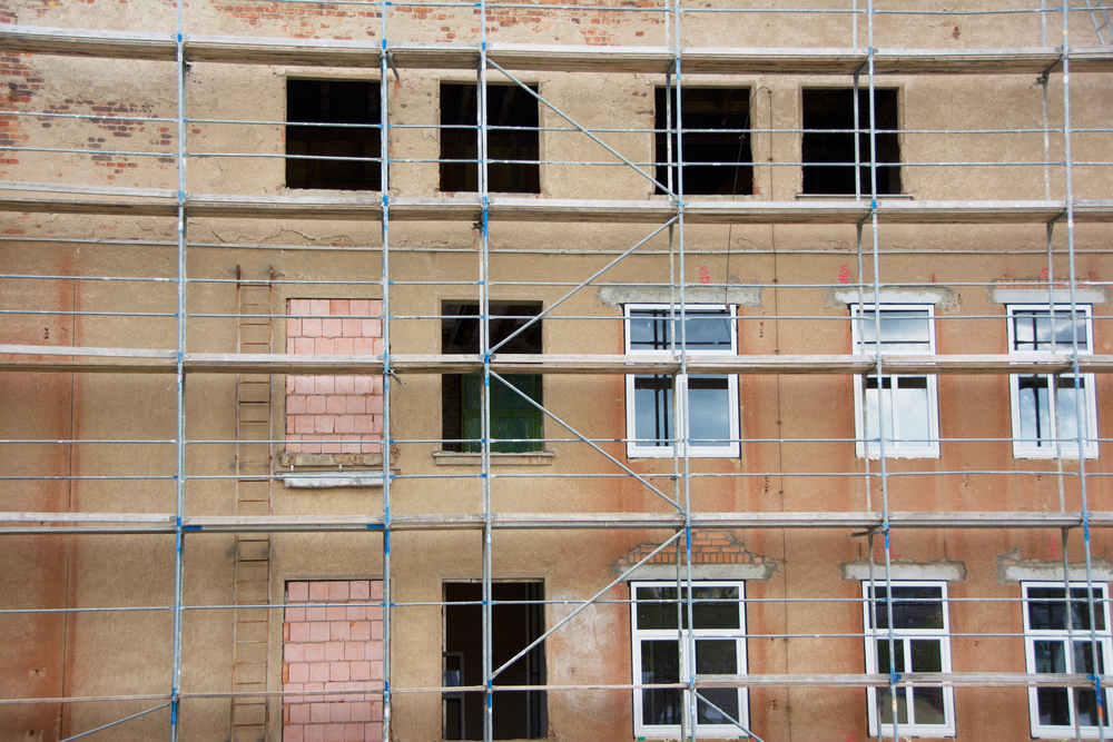 Sanierung-und-Modernisierungsarbeiten – Es ist ein Gerüst an einem Gebäude zu sehen.